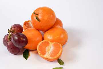 The concept of Tangerine or Mandarin orange with Grapes and Pears on a white background is suitable for design needs, as an illustration for articles about fruits and others.