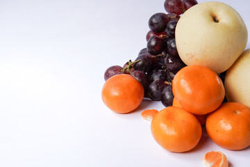 The concept of Tangerine or Mandarin orange with Grapes and Pears on a white background is suitable for design needs, as an illustration for articles about fruits and others.