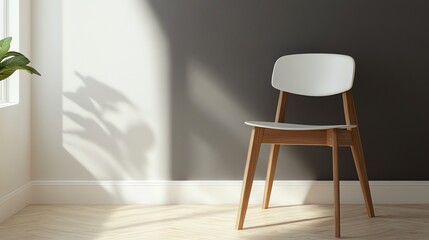 A white chair with wooden legs sits in a room with a white and gray wall, and wood flooring. The sun shines through a window, casting shadows on the wall.