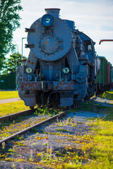 Historic steam engine, front view with rustic details at Estonian railway heritage site. The vintage locomotive in Haapsalu showcases classic industrial design with dual headlights