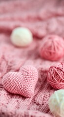 Pink heart-shaped crochet piece surrounded by yarn balls