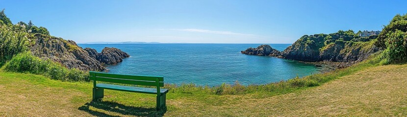 Scenic coastal panorama with a bench overlooking a tranquil bay.