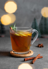 Homemade apple punch with fresh apples, cinnamon and rosemary in a cup on a dark background