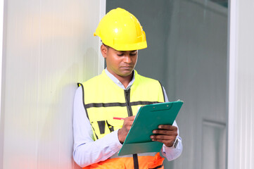 Engineer wearing safety helmet walks to work in industrial plant.