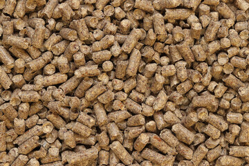 Wood filler for cat toilet, top view. Hygienic filler for pets. Pressed wood, large granules. Pellets. A pile of wood granules. Filler for dogs, cats, domestic rodents. Texture