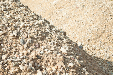 gravel close-up, blue sky and forest in the background