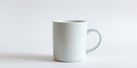 Fototapeta premium A simple, elegant, white ceramic mug, perfect for hot beverages, sits on a plain white background.