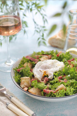 A bowl with salad lyonnaise served for lunch