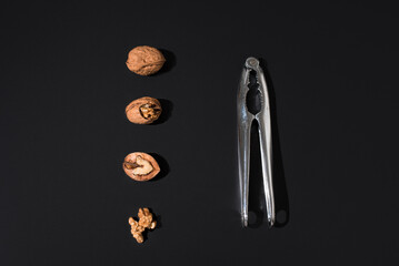 Nueces y cascanueces sobre fondo negro. Vista superior	
