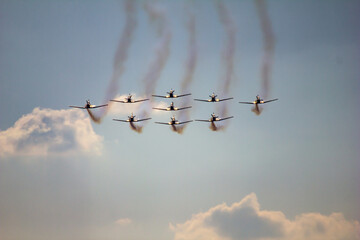 Precision in Formation. A squadron of aircraft flies in perfect formation, trailing smoke against a...