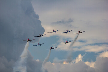 Formation Flight Amid Dramatic Clouds. Eight planes perform a stunning formation maneuver at the Leszno Air Show, Poland, with dramatic cloudscapes as a captivating backdrop.