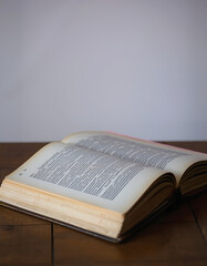 Fototapeta premium Old vintage book on wooden table. Open book with blank pages, Colored gel lighting, with white tones