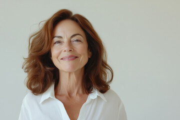 Portrait of attractive smiling middle aged woman in casual atmosphere on light background