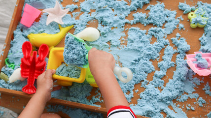 Little Boy Playing with Blue Kinetic Sand at Home. Early Education. Preparing for School. Development