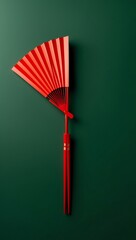 Red Paper Fan and Chopsticks on Green Background: A Minimalist Asian-Inspired Still Life Photography