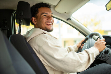 Man smiling sitting in a car, front seat view