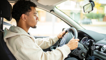 Focused man driving car with hands on steering wheel