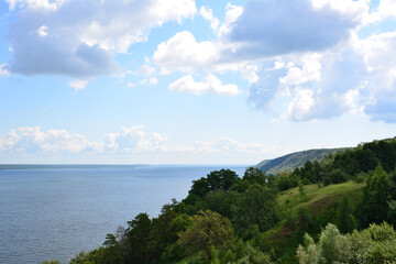 Fototapeta premium a view of the lake from the top of a hill with sky and clouds 