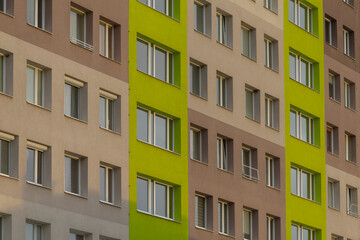 The modern apartment buildings facade showcases a harmonious design with green and neutral...