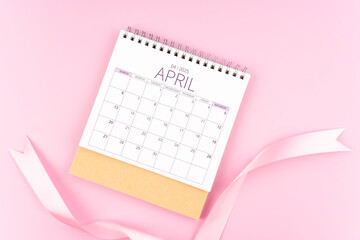 April 2025 desk calendar with pink pastel ribbon.