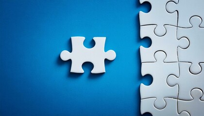 Fototapeta premium Puzzle pieces - Last piece of white puzzle ready to complete the mission on blue background