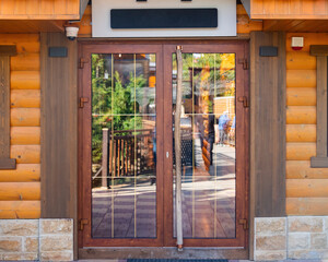 wooden door with glass inserts, opaque and reflecting the street in a restaurant or hotel building...