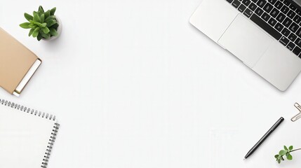 A flat lay of a neatly arranged desk setup featuring a laptop, pen, and notebook, all placed against a white background.