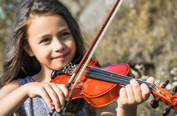 Little girl learns to play violin. Musical instrument class concept. Musical education for children. © Victoria