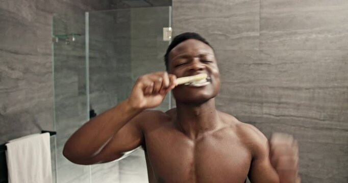 Brushing teeth, face and black man with dance for morning cleaning, dental care and toothbrush grooming. Bathroom, healthcare and African guy with pov for oral health, toothpaste hygiene or whitening