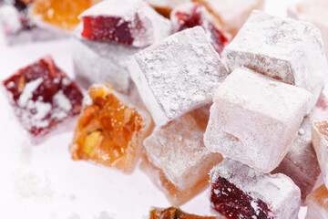 Sweet food Turkish delight, assorted rahat locum in form of cubes with nuts and powdered sugar, traditional food, on white background