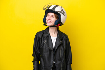 Young English woman with a motorcycle helmet isolated on yellow background thinking an idea while looking up