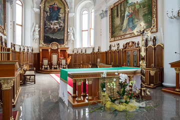 A church with a green table and a painting of a woman on the wall