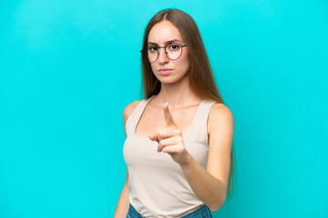 Young caucasian woman isolated on blue background frustrated and pointing to the front