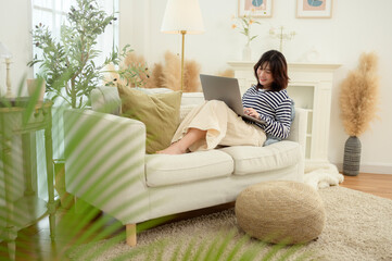 Woman Working on Laptop in a Bright and Cozy Living Room