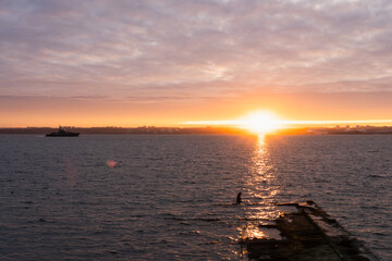A military boat enters Tallinn Bay early in the morning at sunrise in winter.