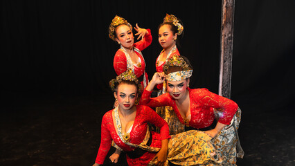 a group of traditional Javanese dancers wearing red costumes which provide a dramatic effect on the stage