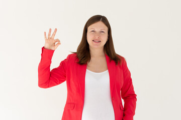 Young beautiful woman wearing red jacket over isolated white background smiling positive doing ok sign with hand and fingers. Successful expression.