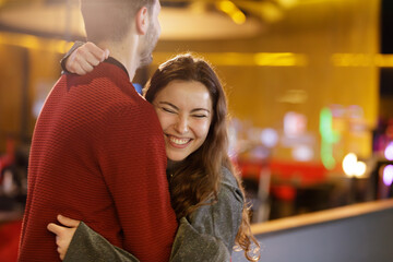 Couple show affection and complicity in the form of hugs and smiles in the afternoon of games at the bowling alley, they are happy because they are winning in the bowling competition.