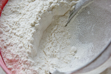 A bowl of flour that stands on the table, and in it is a sifter for advancement. Close up.