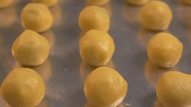 Closeup Nastar cookies neatly arranged on a baking sheet ready to be smeared with egg yolk and baked in an oven with sufficient heat. Camera movement ending blurred