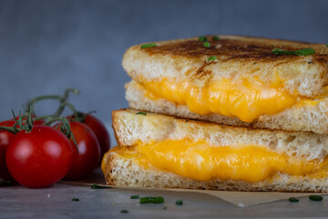 Grilled Cheese with melting cheese dripping from the inside. The sandwich is cut in half and ready to eat.