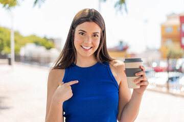 Young pretty Brazilian woman holding a take away coffee at outdoors with surprise facial expression