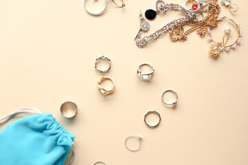 Stylish feminine golden and silver rings on beige background. Top view. flatlay