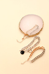 golden and silver jewelry on beige background. top view. hair jewelry, accessories, earrings, necklace, bracelet