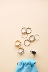 Stylish feminine golden and silver rings on beige background. Top view. flatlay