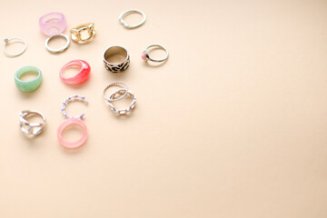 Stylish feminine golden and silver rings on beige background. Top view. flatlay