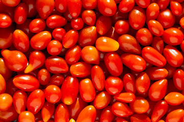 Background of fresh, small, red tomatoes.