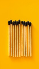Artistic minimalist design featuring matches on a bright yellow background showcasing simplicity