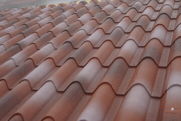 The roof of the house is covered with sandwich panels in the form of ceramic tiles. The wet surface after the recent rain emphasizes the strength of the roofing material. Modern and weather-resistant.