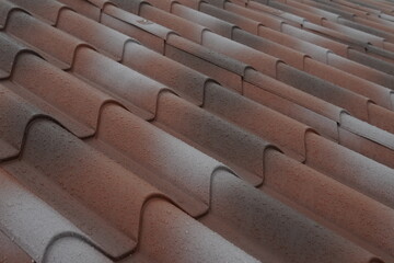 The roof of the house is covered with sandwich panels in the form of ceramic tiles. The wet surface after the recent rain emphasizes the strength of the roofing material. Modern and weather-resistant.